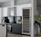 Modern kitchen with a wine cooler next to a stove and cabinets.