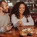 INSIGNIA ACACIA AND SLATE SERVING BOARD WITH CHEESE TOOLS-with man and woman cutting cheese on the serving board and drinking wine