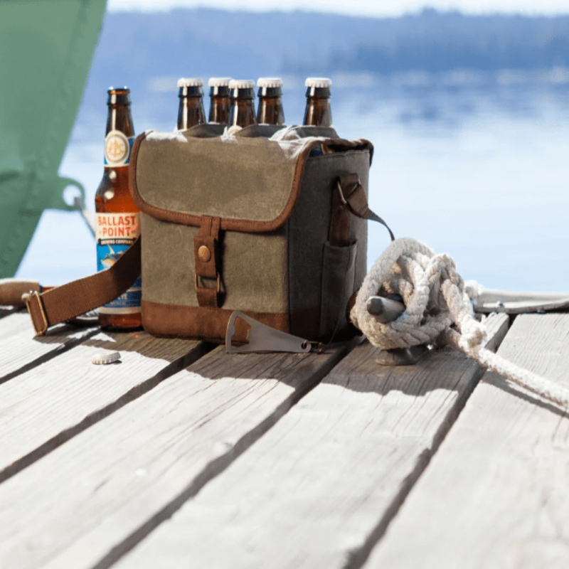 Legacy Barware Beer Caddy Cooler Tote With Opener - Khaki Green with Brown Accents - tote on picnic table with beer and a boat