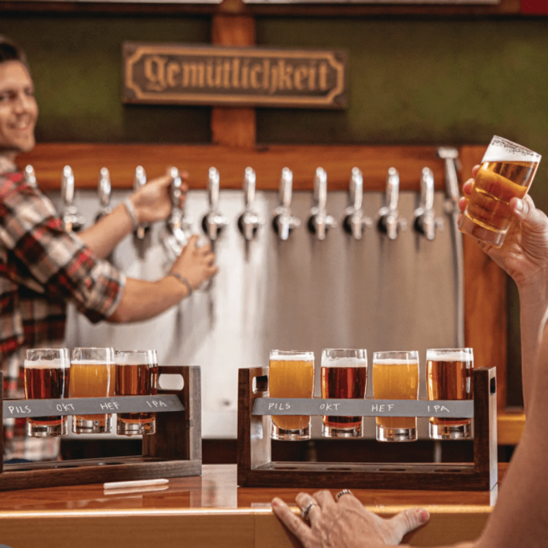 Craft Beer Flight Beverage Sampler - two sets of the sampler sitting on a bar with a man pouring beer