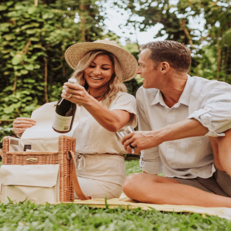 Picnic Time Corsica Wine and Cheese Picnic Basket - man and woman at a picnic holding wine bottle