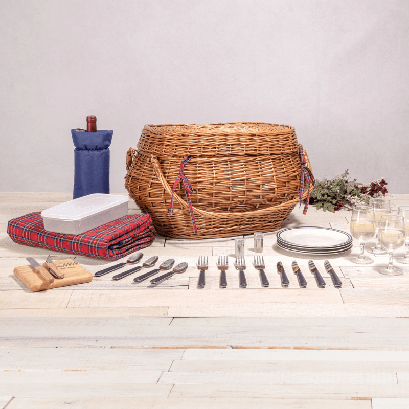 Picnic Time Highlander Picnic Basket - Closed view with utensils, blanket, plates, glasses, wine bottle, and cheese board beside.