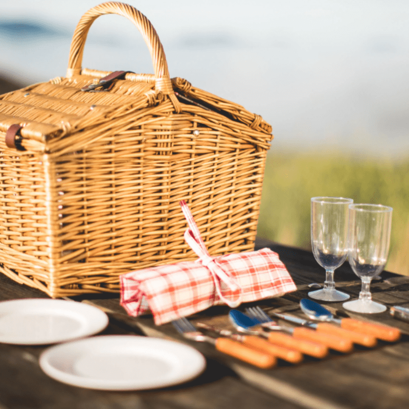 Picnic Time Piccadilly Picnic Basket - Red & White Plaid Pattern - picnic basket on table with plates, and wine glasses