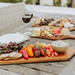 Toscana Artisan 30" Acacia Charcuterie Board - 3 charcuterie boards with appetizers and glasses of win