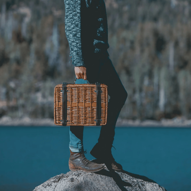 Picnic Time Champion Picnic Basket - Navy Blue - Man carrying the picnic basket by a lake